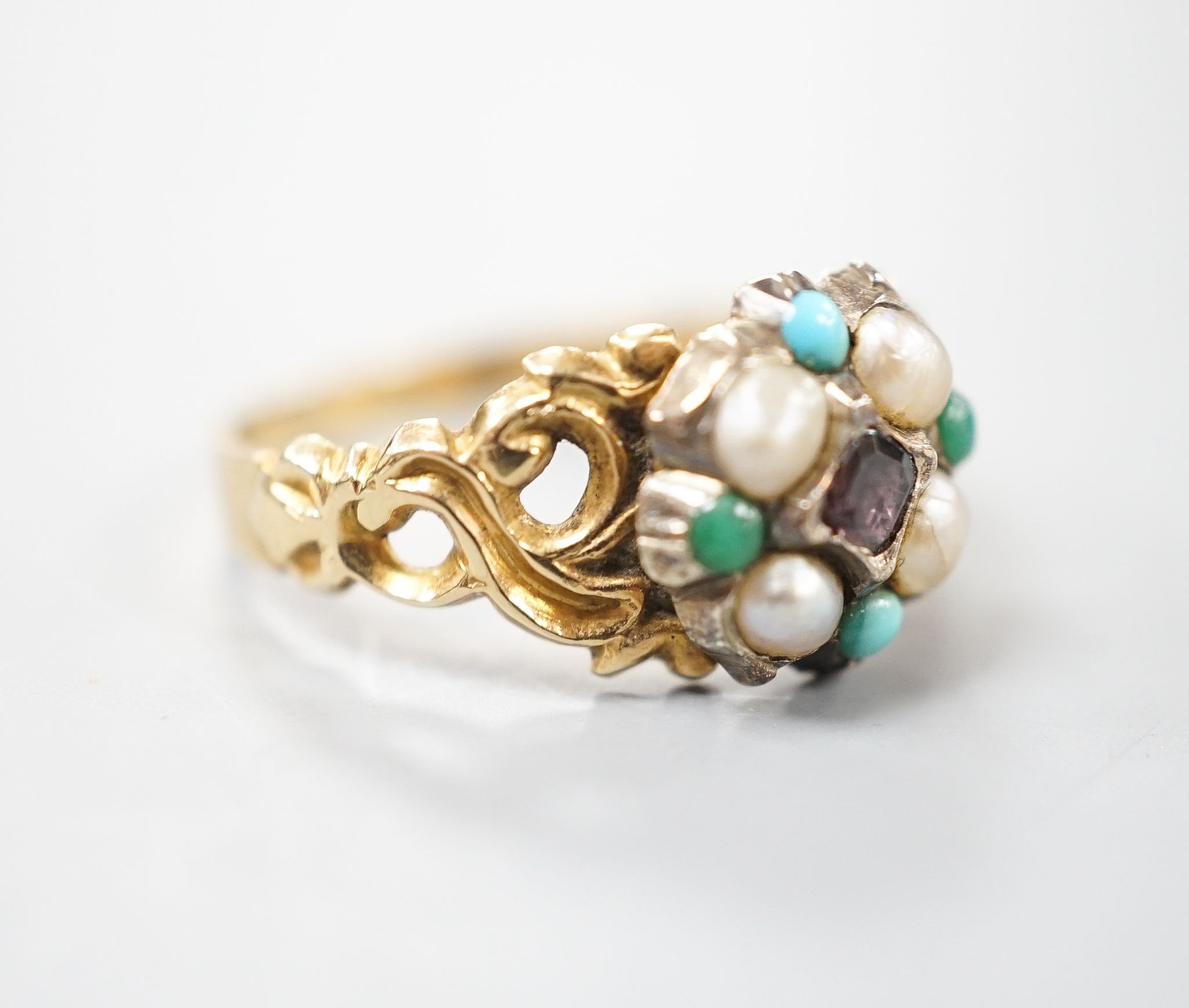 A late Victorian yellow metal, garnet, turquoise and split pearl cluster set dress ring, size M, gross weight 2.9 grams.